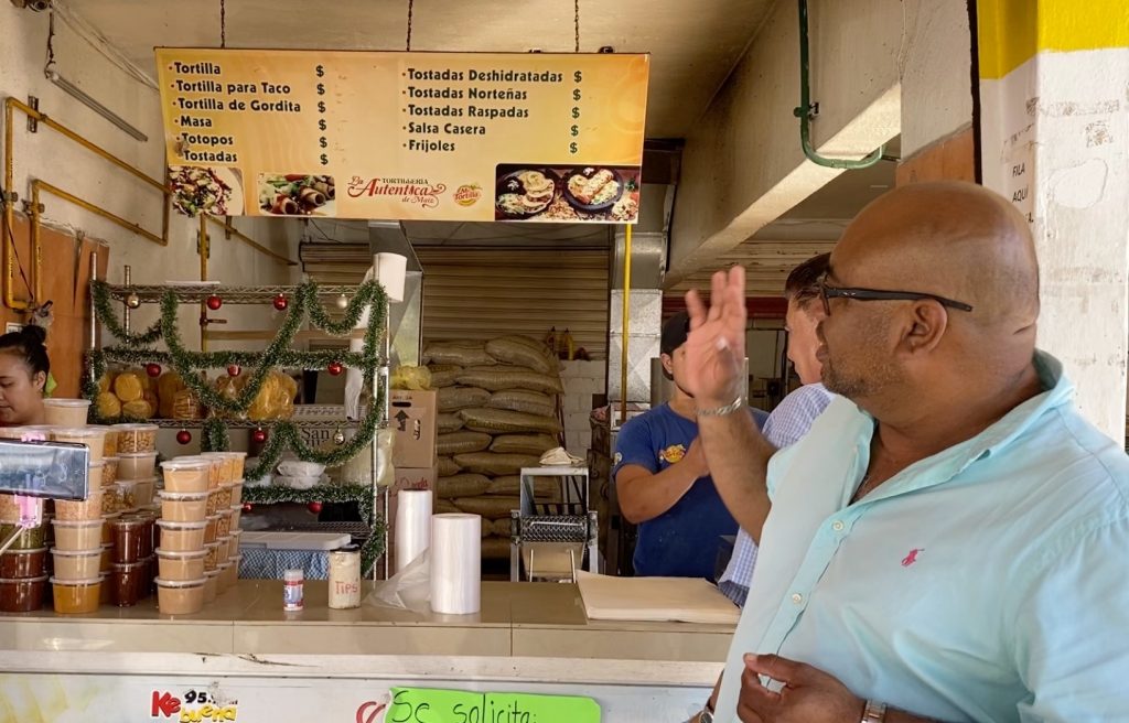 Enrique explaining tortilla making process at the tortilla factory during our foodie cruise excursion.