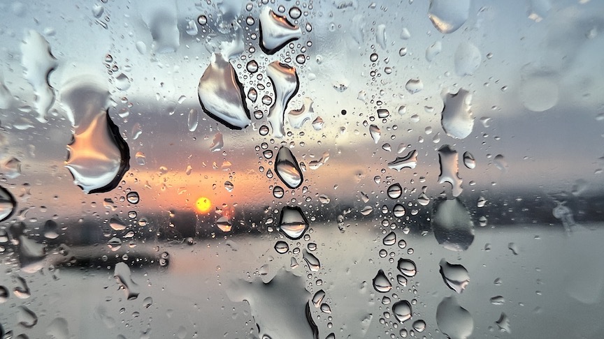 Small details sunrise through raindrops