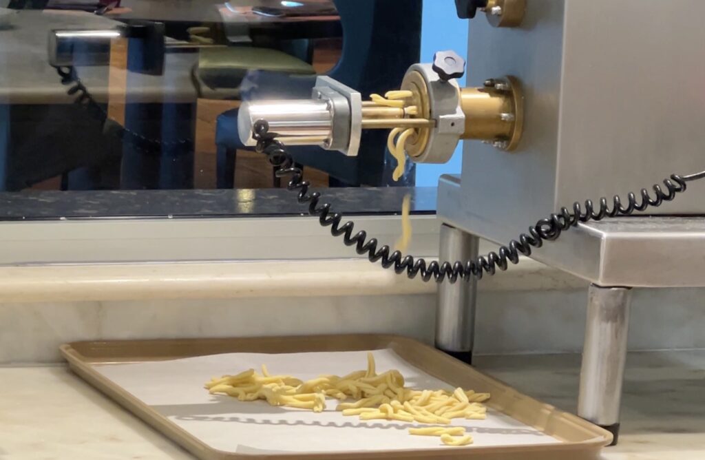 Pasta extruding from machine