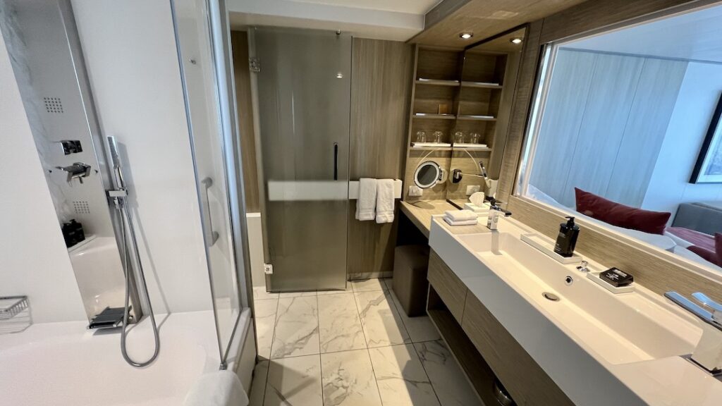 Luxuriously appointed bathroom in Celebrity Ascent Sky Suite, complete with double sinks, makeup area, shower, and modern amenities.