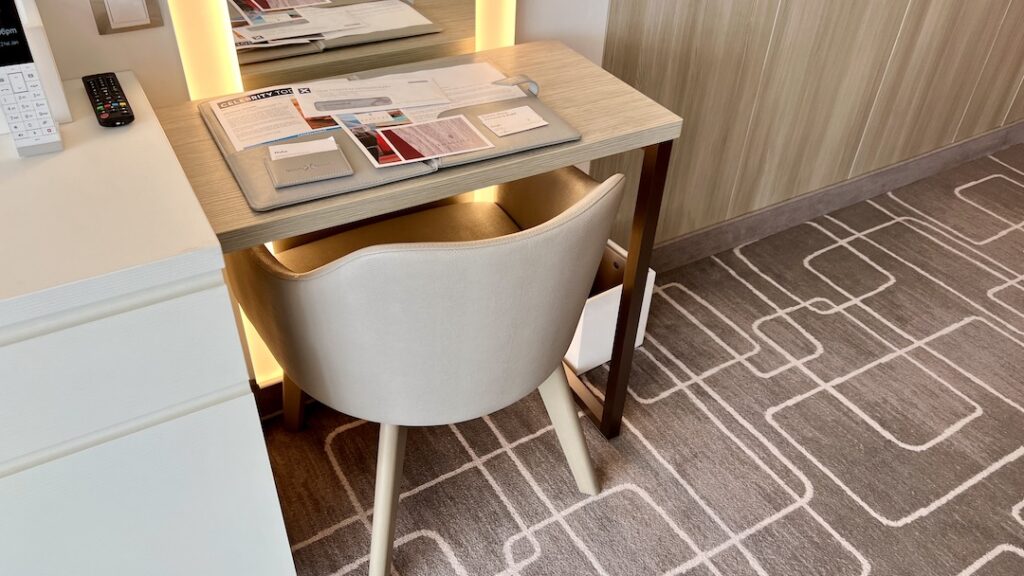 Desk with chair and large lighted mirror in the Ascent Sky Suite.